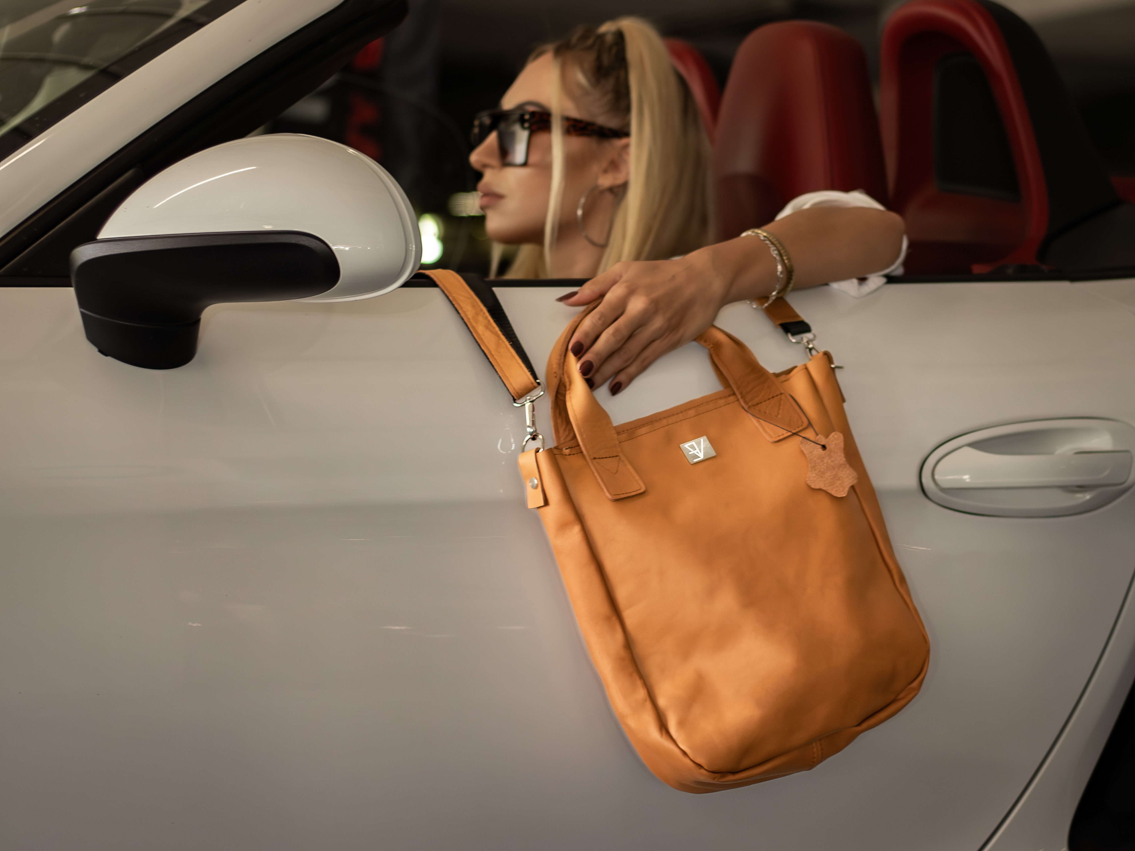 zdjęcie przedstawiające kobietę w samochodzie z torebką